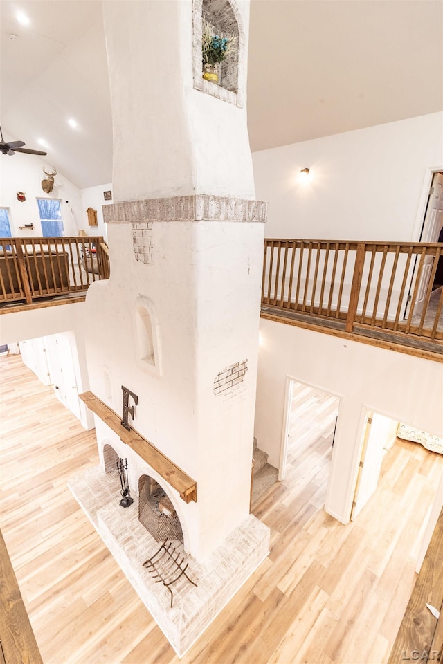 stairs with hardwood / wood-style floors, ceiling fan, and lofted ceiling