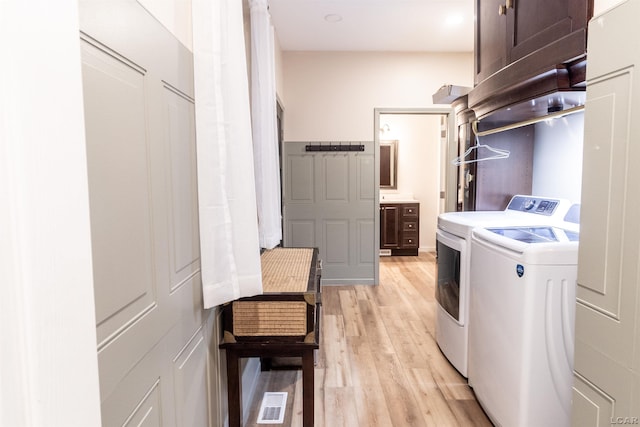 washroom featuring independent washer and dryer and light wood-type flooring