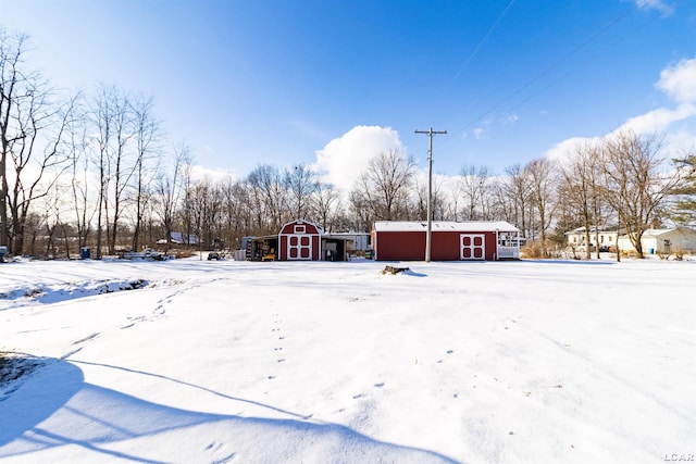 yard covered in snow with an outbuilding