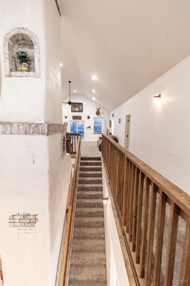 stairs featuring ceiling fan and vaulted ceiling