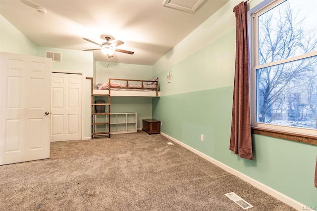 unfurnished bedroom featuring carpet, ceiling fan, and a closet