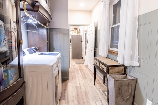 laundry room featuring independent washer and dryer and light hardwood / wood-style flooring