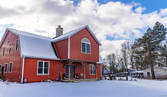 view of snow covered back of property