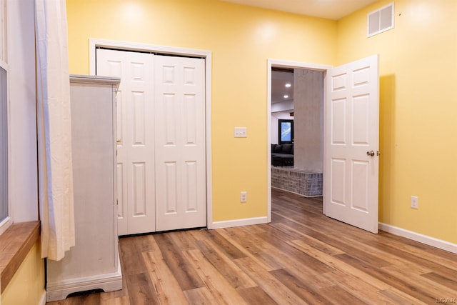 unfurnished bedroom with a closet and light wood-type flooring