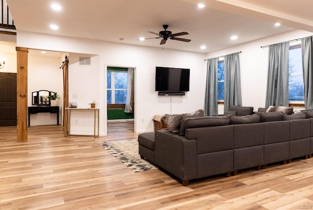 living room with ceiling fan and light hardwood / wood-style flooring