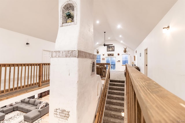 staircase featuring ceiling fan and high vaulted ceiling