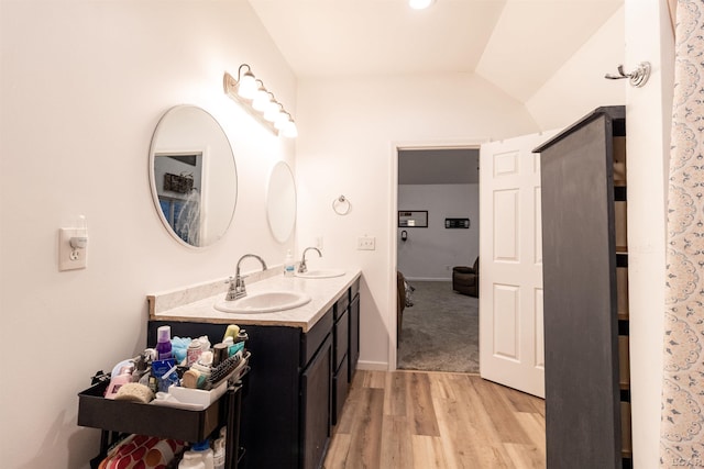 bathroom featuring vanity, vaulted ceiling, and hardwood / wood-style flooring