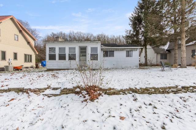 snow covered house featuring central air condition unit