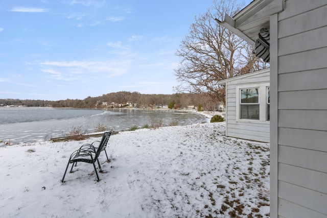 snowy yard featuring a water view