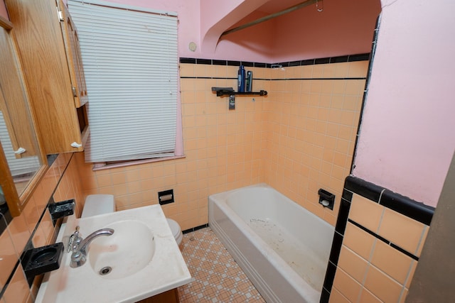 bathroom featuring tile patterned floors, vanity, toilet, and tile walls