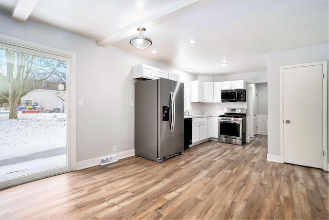 kitchen with appliances with stainless steel finishes, light wood-type flooring, tasteful backsplash, beamed ceiling, and white cabinets