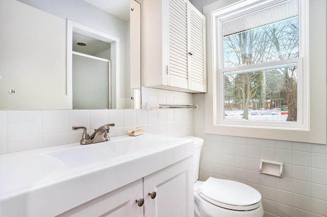 bathroom featuring vanity, toilet, and a shower with shower door