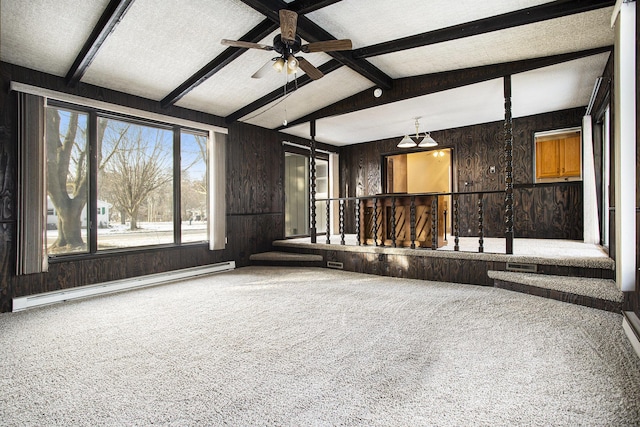 interior space with a textured ceiling, wooden walls, baseboard heating, vaulted ceiling with beams, and ceiling fan