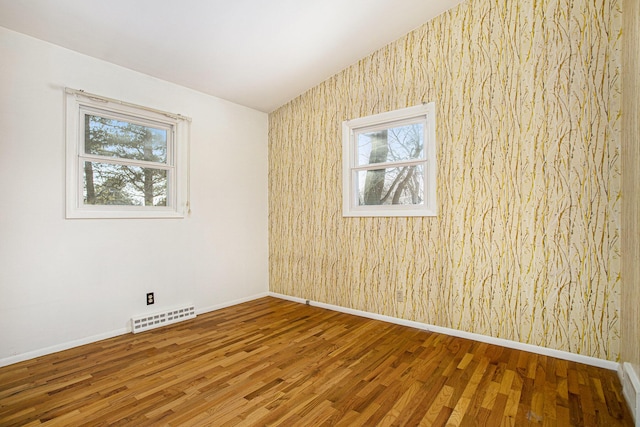 spare room with wood-type flooring and plenty of natural light