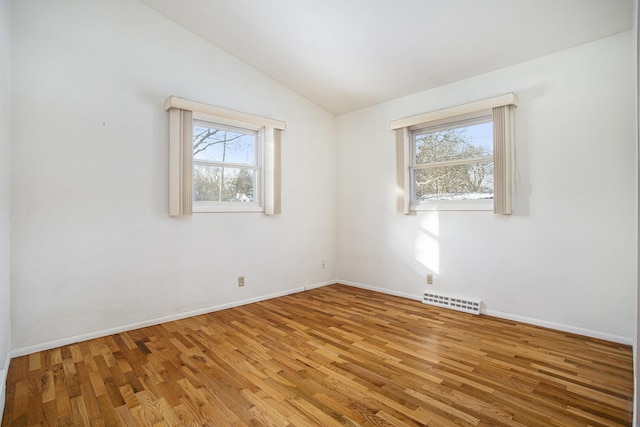 unfurnished room featuring hardwood / wood-style floors and lofted ceiling