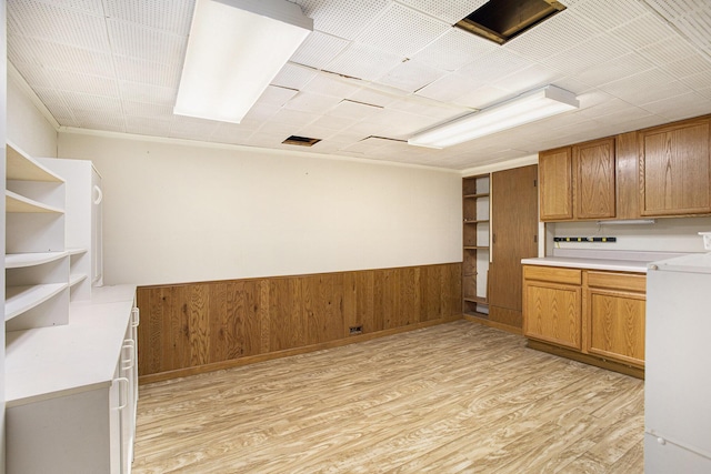 kitchen with wooden walls and light hardwood / wood-style floors