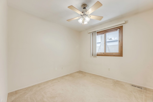 carpeted spare room featuring ceiling fan