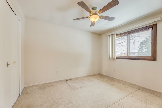 carpeted empty room featuring ceiling fan