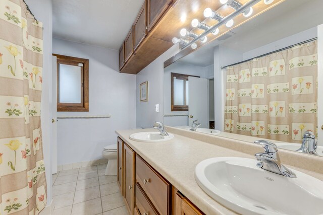 bathroom with toilet, tile patterned flooring, and vanity