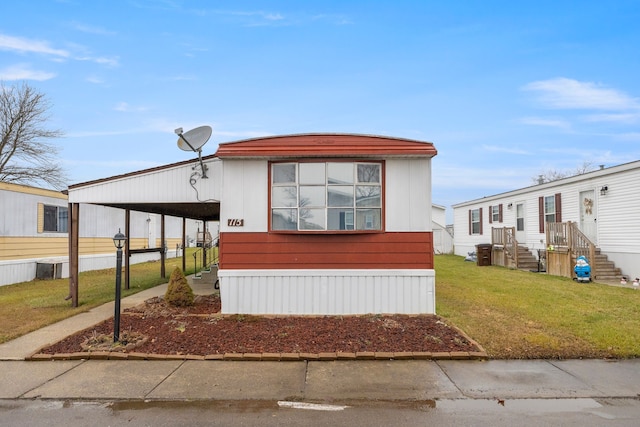 view of front of home with a front lawn and a carport