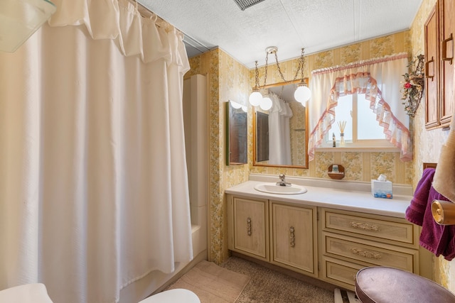 full bathroom featuring a textured ceiling, toilet, vanity, and shower / tub combo with curtain