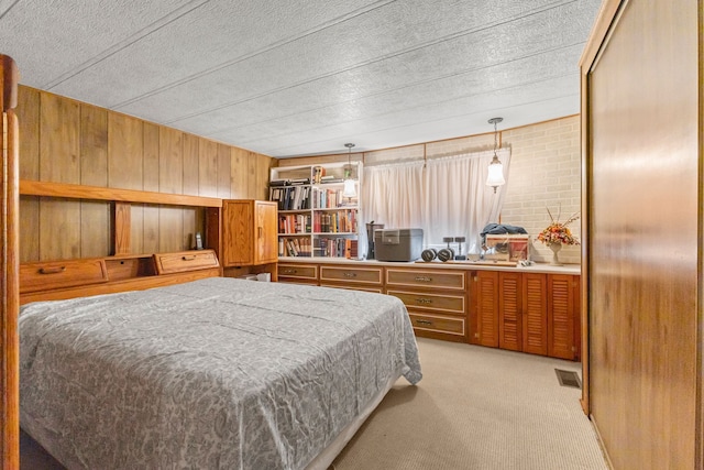 carpeted bedroom featuring wood walls and a textured ceiling