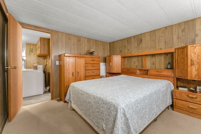 carpeted bedroom featuring wood walls and washer / clothes dryer