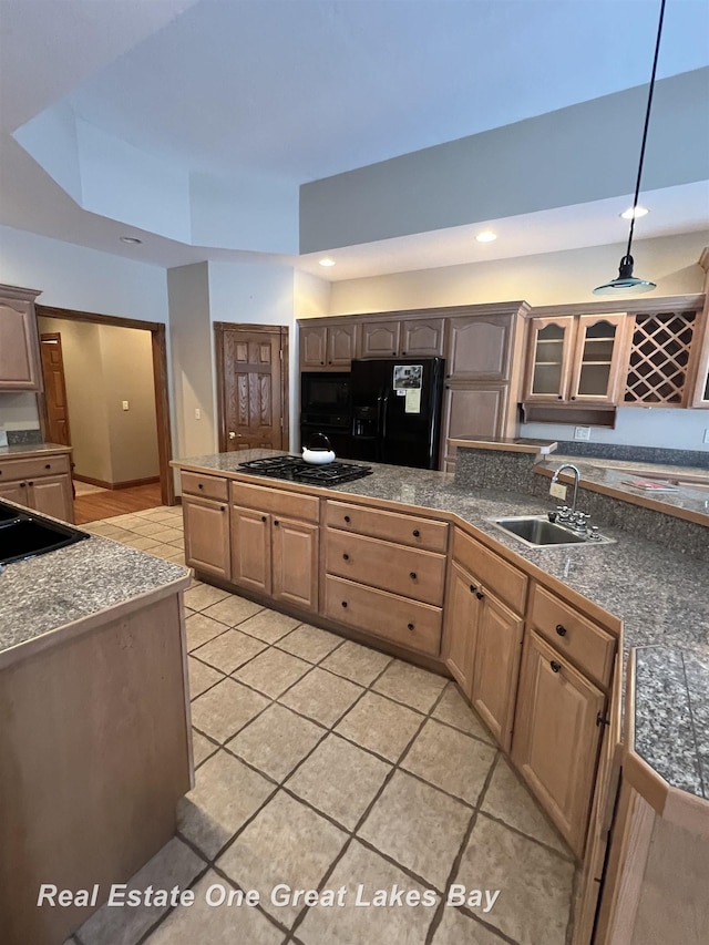 kitchen featuring sink, decorative light fixtures, a tray ceiling, light tile patterned floors, and black appliances