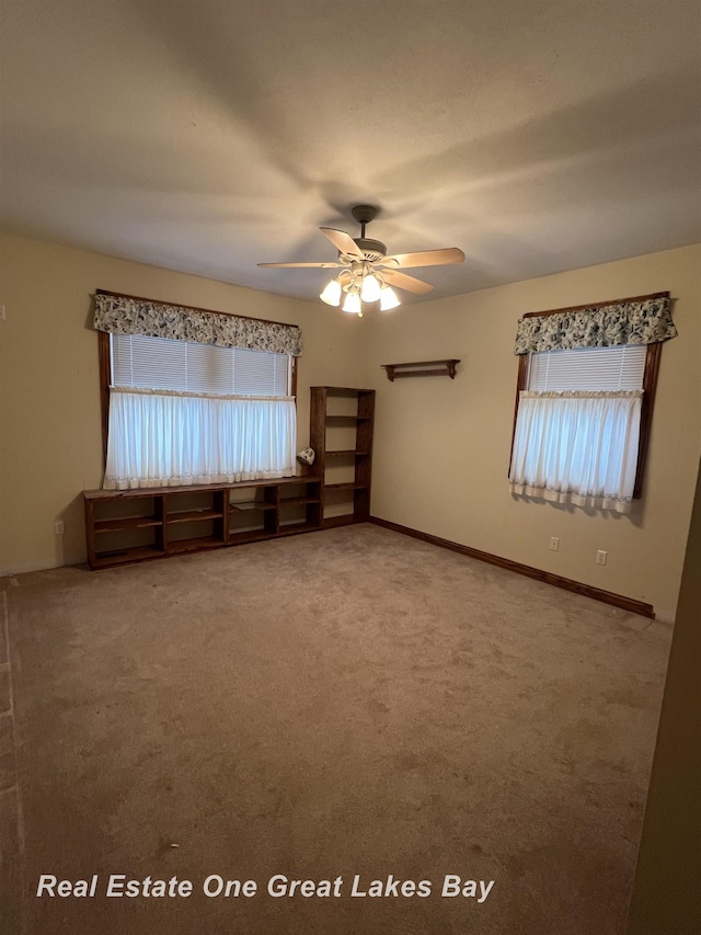 carpeted empty room featuring ceiling fan