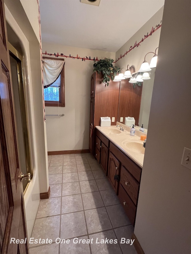 bathroom with tile patterned floors, vanity, and combined bath / shower with glass door