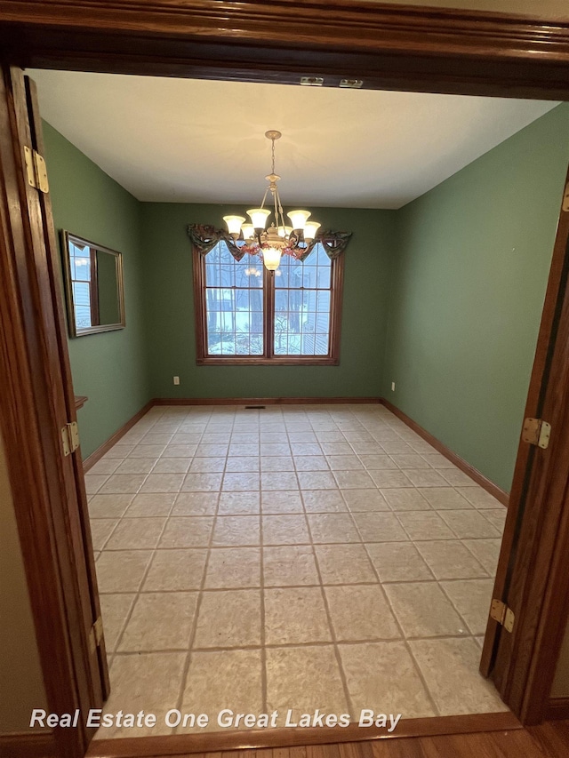 unfurnished dining area with a notable chandelier and light tile patterned floors