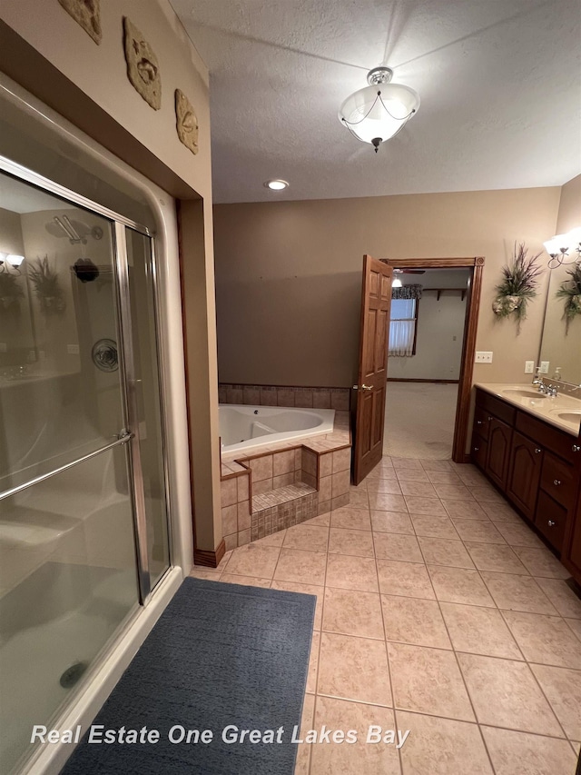 bathroom featuring tile patterned floors, vanity, a textured ceiling, and shower with separate bathtub