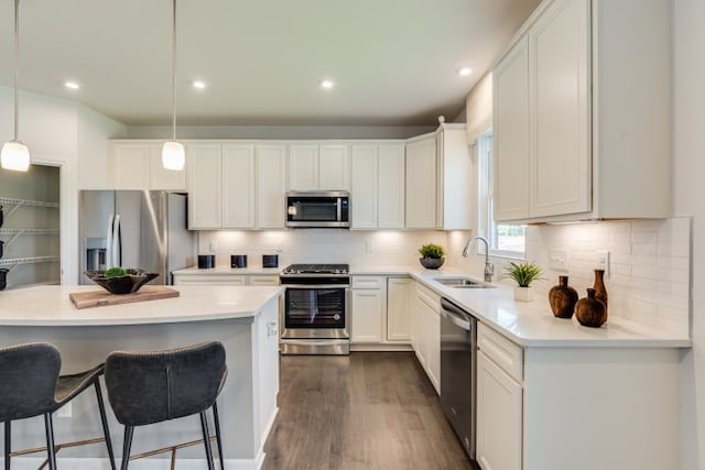 kitchen featuring pendant lighting, sink, white cabinets, and appliances with stainless steel finishes