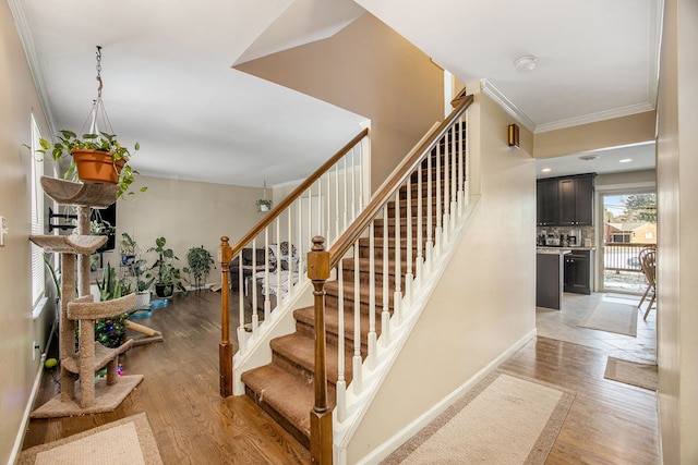 stairs with hardwood / wood-style flooring and crown molding