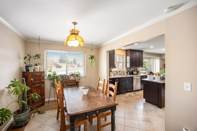 dining area with crown molding, sink, and light tile patterned floors