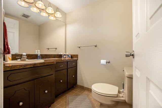 bathroom with tile patterned flooring, vanity, and toilet