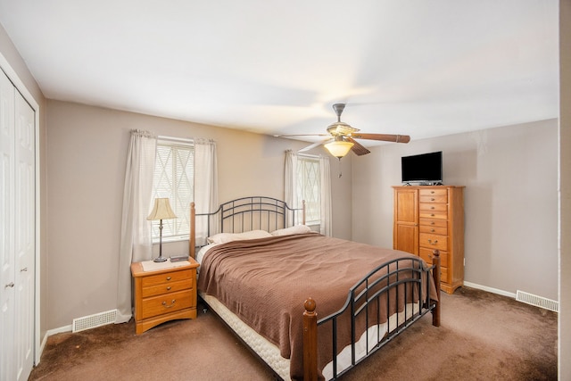 bedroom with dark colored carpet, ceiling fan, and a closet