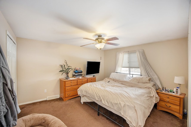 bedroom featuring dark colored carpet, ceiling fan, and a closet