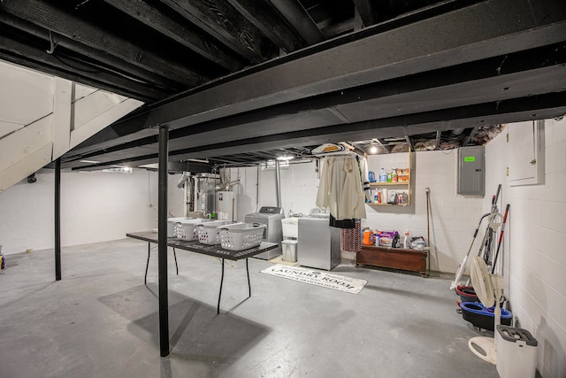 basement featuring washing machine and dryer, water heater, and electric panel