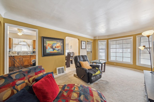 carpeted living room with ceiling fan