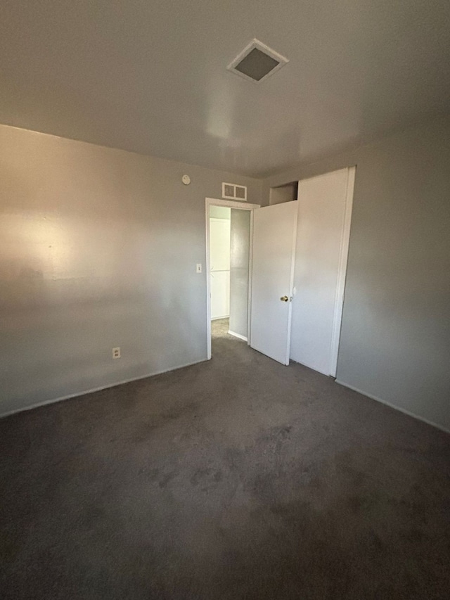 unfurnished bedroom featuring dark carpet