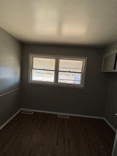 spare room with dark wood-type flooring