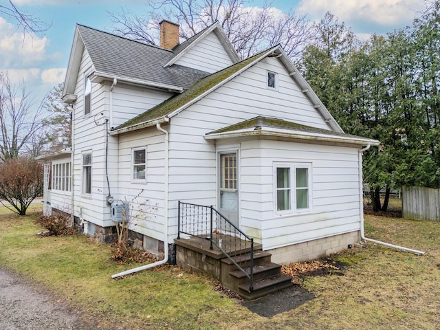 rear view of property featuring a lawn