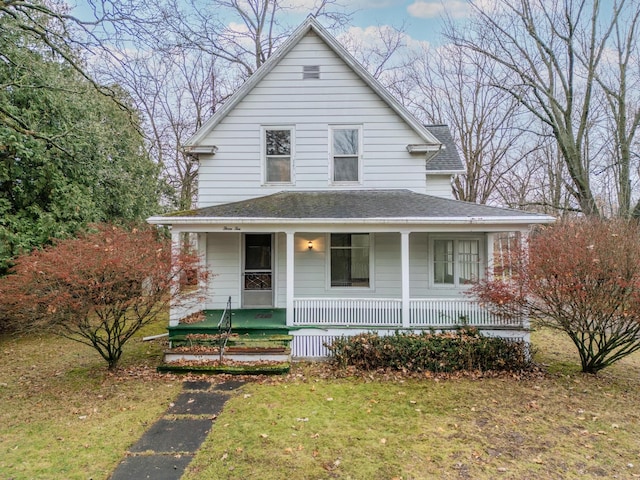 farmhouse-style home with a front yard and covered porch