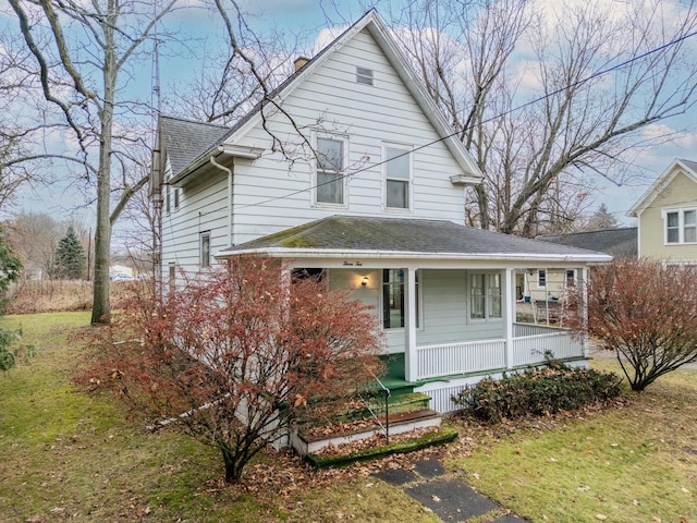 view of front of home with covered porch and a front lawn