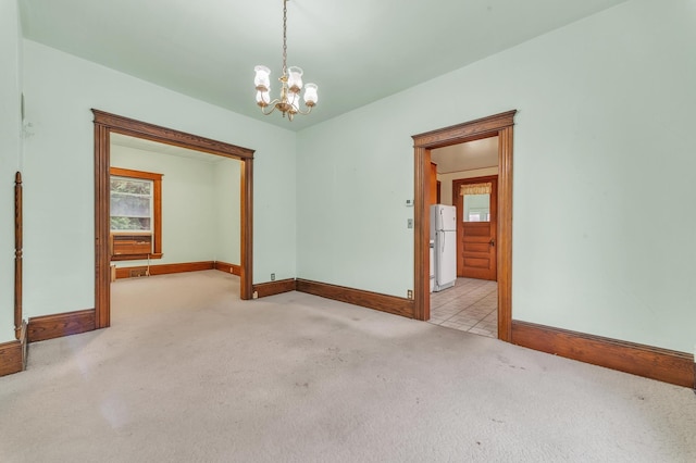 unfurnished room with an inviting chandelier and light carpet