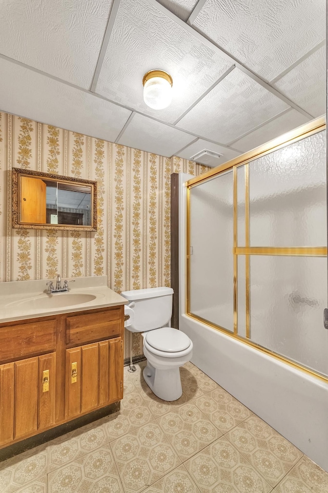 full bathroom featuring combined bath / shower with glass door, toilet, and vanity