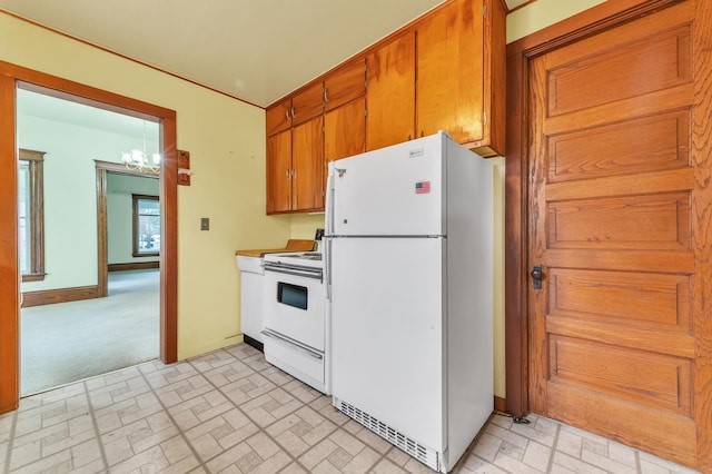 kitchen featuring white appliances and a chandelier