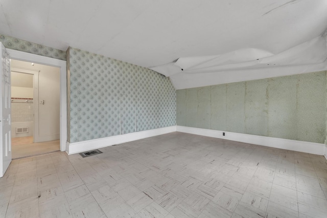 spare room featuring lofted ceiling