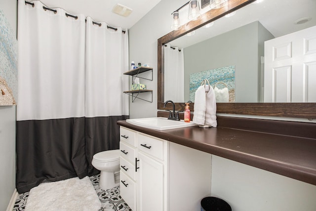 bathroom with toilet, vanity, and tile patterned flooring